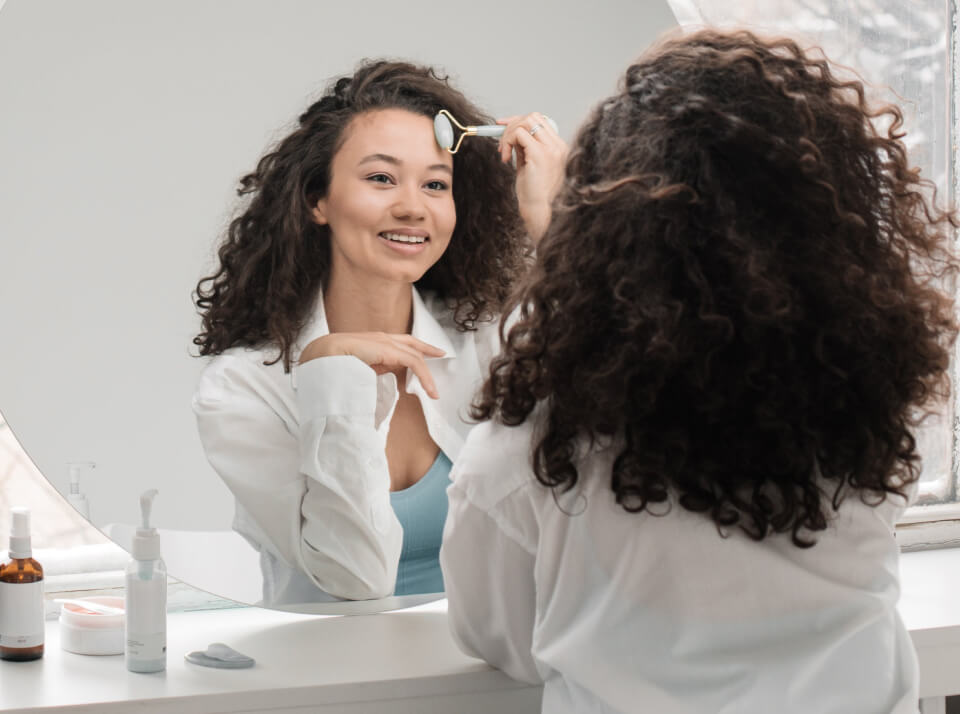 Woman using a facial massage roller during a skincare routine